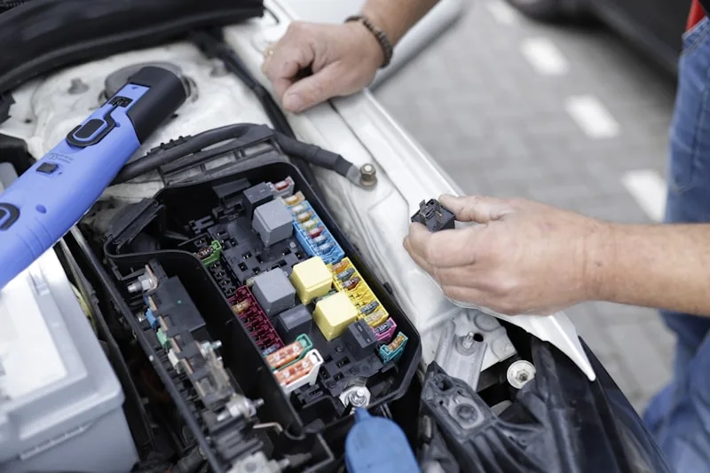 Auto technician diagnosing vehicle electronics